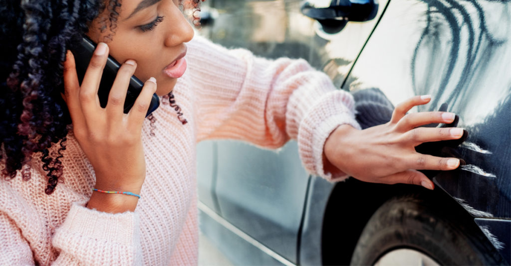 women examine car damage for minor vs severe accident